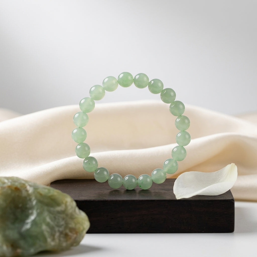 Bracelet d'aventurine sur socle en bois avec pierre brute et pétale blanc. Ambiance zen et naturelle.