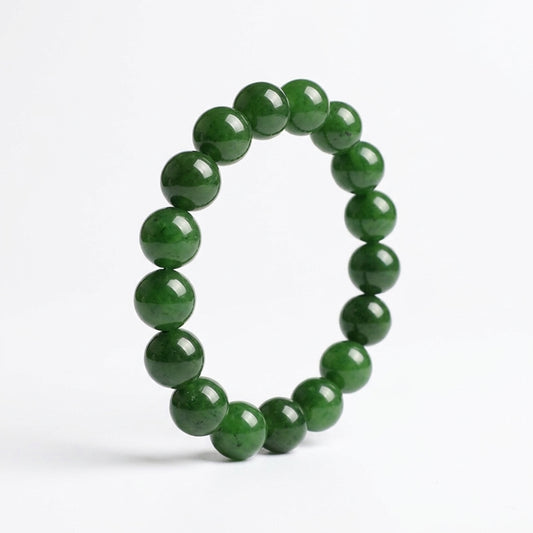 Bracelet circulaire en perles de jadéite naturelle sur fond blanc. Vue de profil montrant le polissage miroir.