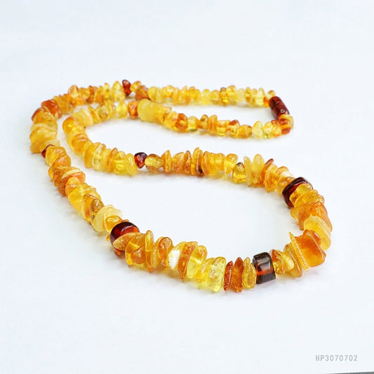 Collier en ambre naturel aux nuances miel et cognac, présenté sur fond blanc épuré. L'Atelier Wen.
